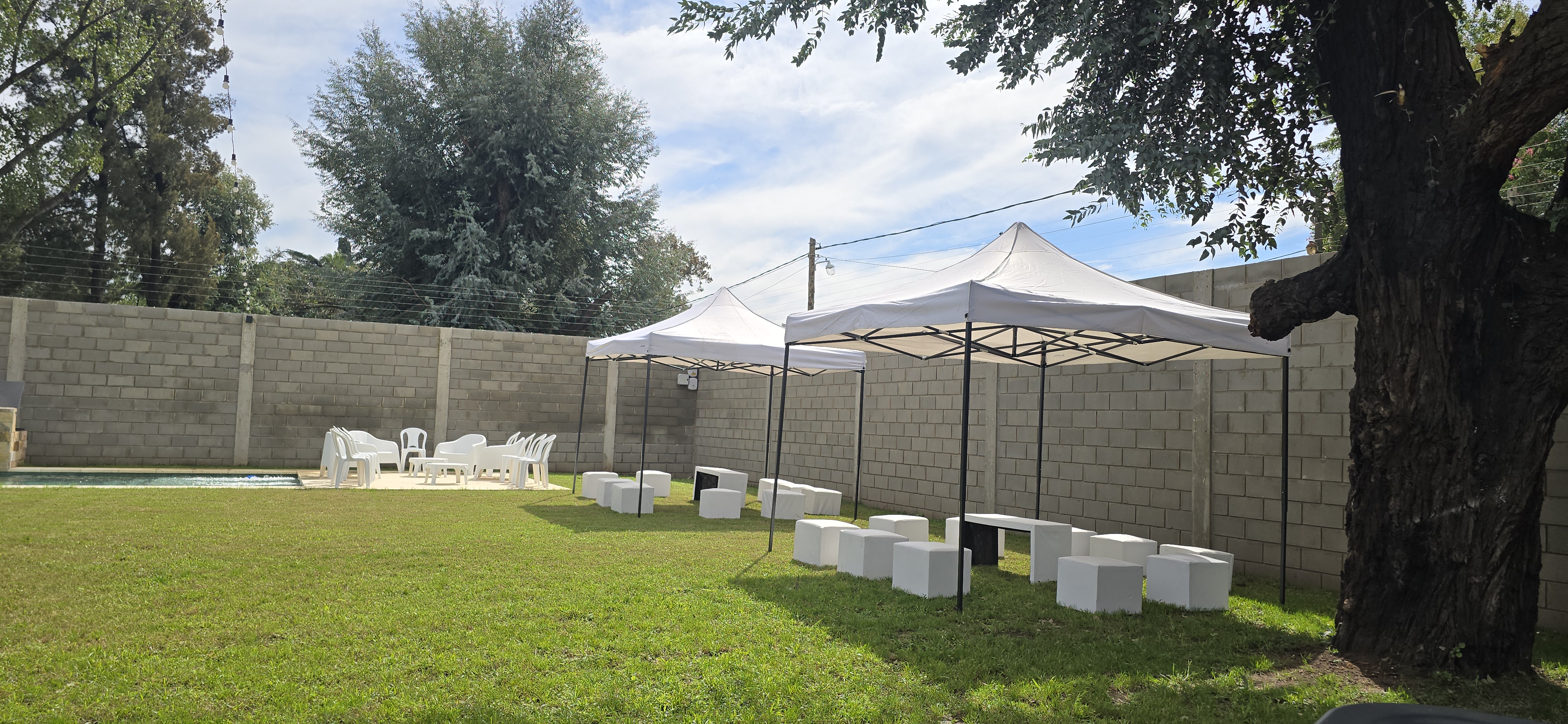 Parque de día con gazebo blanco y pufs